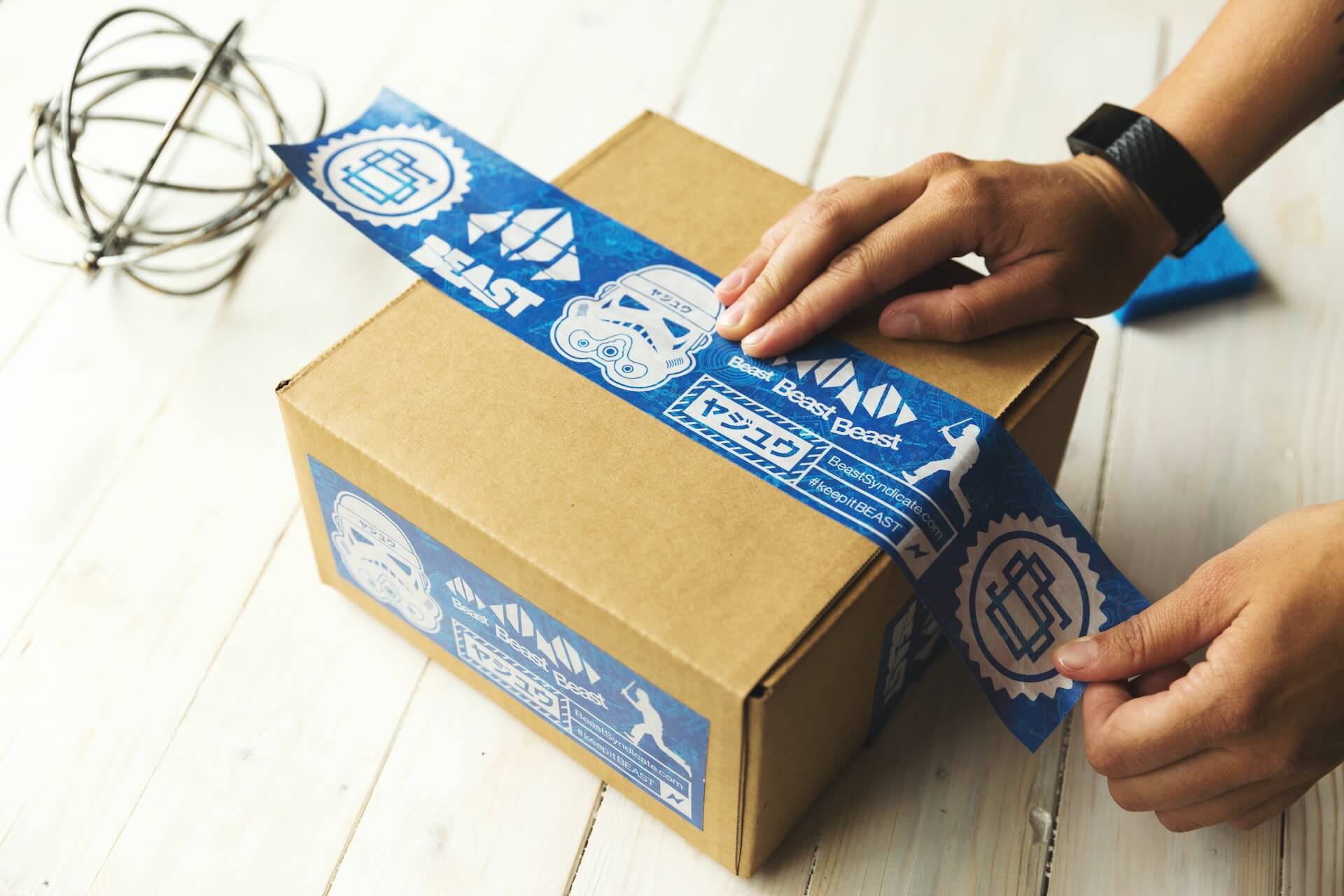 Person sealing carton parcel with tape